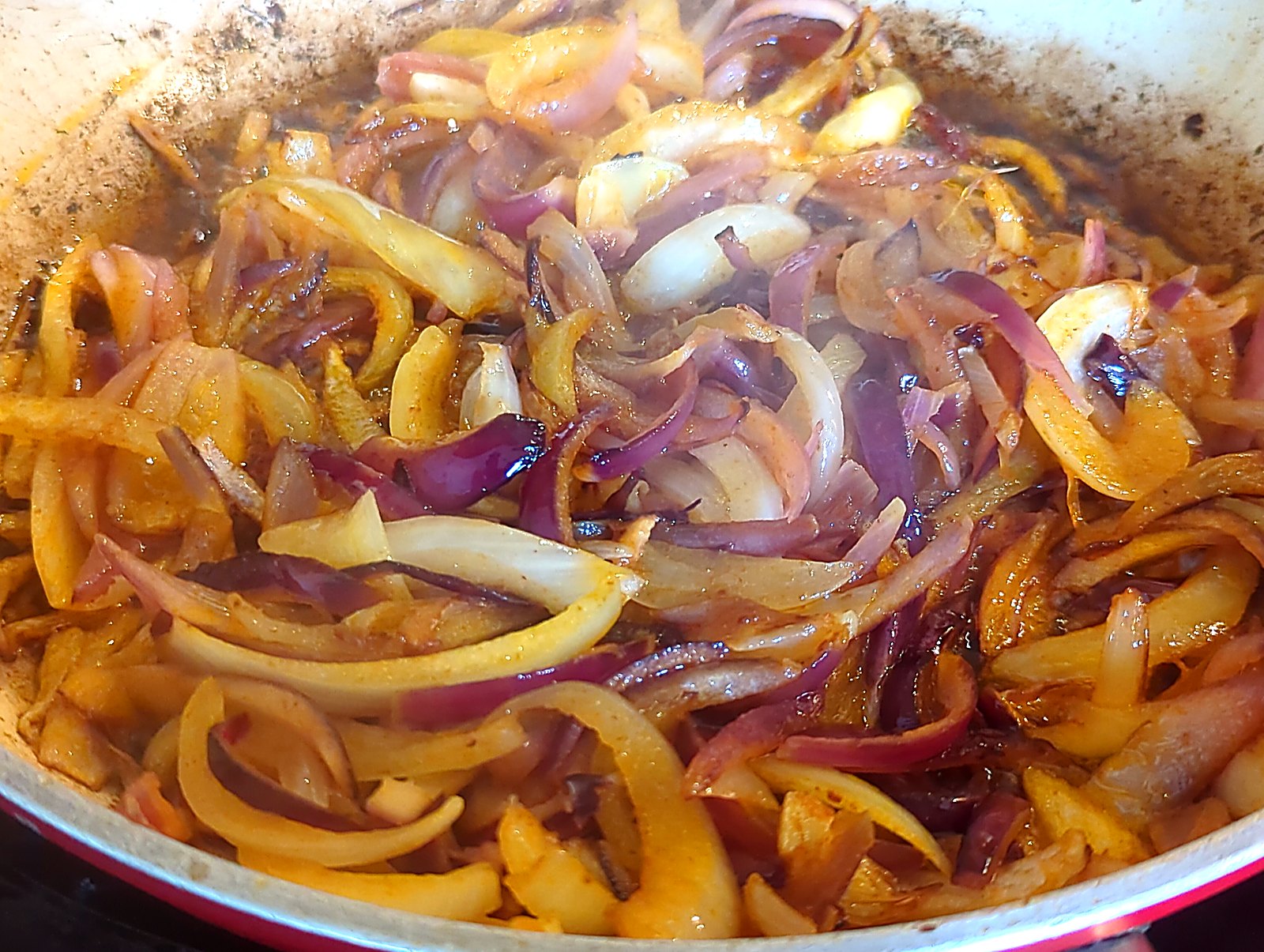 La mjaddara, ou comment j'ai séduit ma conjointe avec du riz, des lentilles et une boîte de tomates image Oignons caramélisés dans la poêle, bruns et luisants, prêts à garnir la mjaddara.