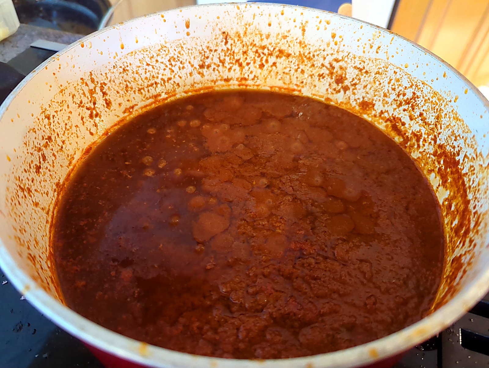 La mjaddara, ou comment j'ai séduit ma conjointe avec du riz, des lentilles et une boîte de tomates image Sauce tomate au cumin en train de mijoter, l'huile d'olive remontée à la surface.
